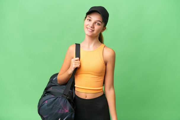 Teenager caucasian girl with sport bag over isolated background smiling a lot - Photo, Image