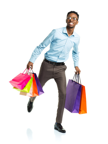 Feliz afroamericano hombre sosteniendo bolsas de compras en blanco backgr
 - Foto, imagen