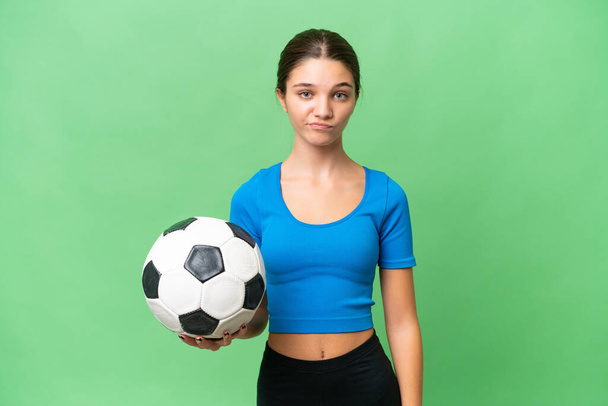Teenager kavkazský dívka hrát fotbal přes izolované pozadí se smutným výrazem - Fotografie, Obrázek