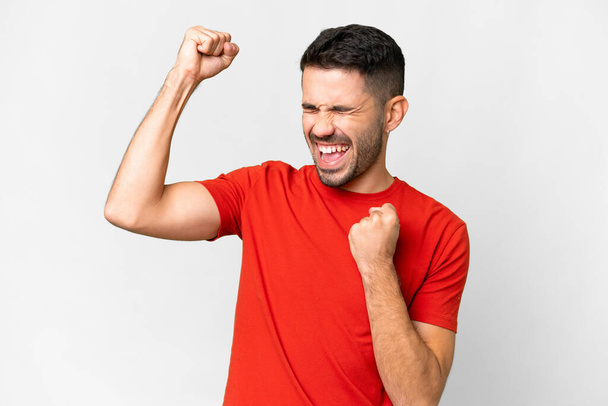 Young handsome caucasian man over isolated white background celebrating a victory - Foto, immagini