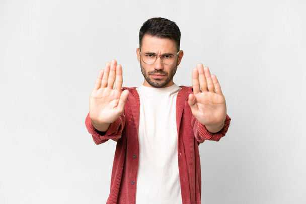 Young handsome caucasian man over isolated white background making stop gesture and disappointed - Photo, Image