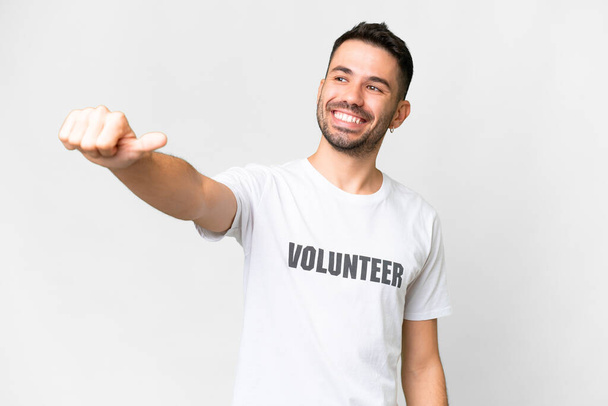 Young volunteer caucasian man over isolated white background giving a thumbs up gesture - Φωτογραφία, εικόνα