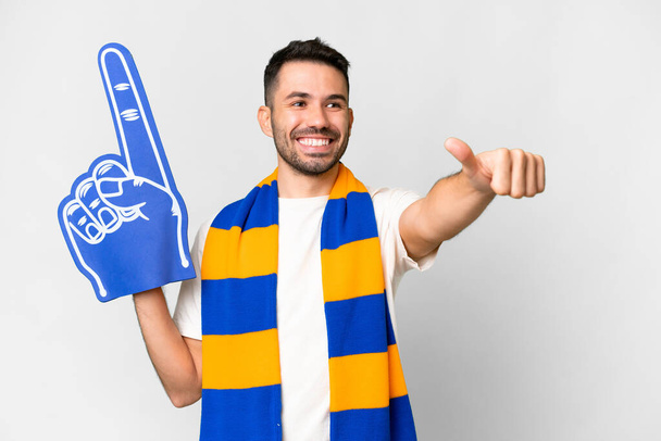 Young caucasian sports fan man over isolated white background giving a thumbs up gesture - Photo, image