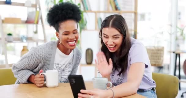 コーヒーショップ、電話やビデオ通話で女性の友人は、連絡先をオンラインで話をしながら手を振っ。カフェやレストランでおしゃべりをする若い女性や友人とのカフェ、モバイル、または仮想通信. - 映像、動画