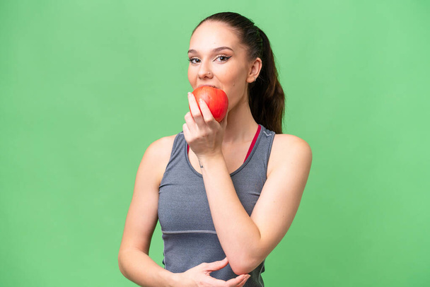Mladý kavkazský žena přes izolované pozadí jíst jablko - Fotografie, Obrázek