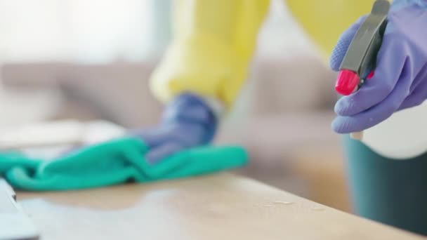 Ręce kobiety sprzątającej stół sprayem, butelką i tkaniną, sprzątającej w czystym domu lub biurze. Prace domowe, smugi i sprzątaczka lub sprzątaczka ścierająca kurz lub brud z biurka gumowymi rękawiczkami - Materiał filmowy, wideo