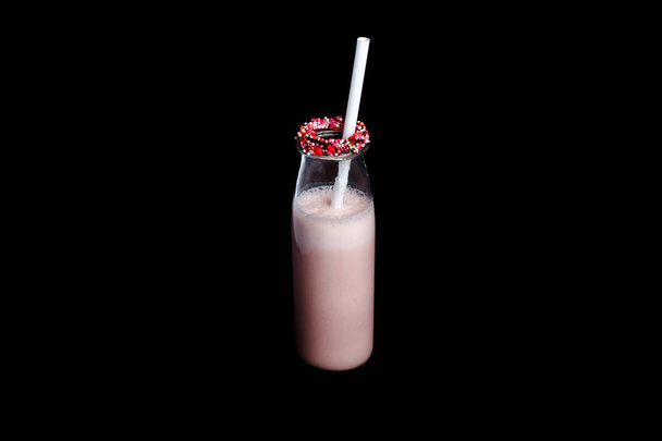 Pink milkshake bottle isolated black background. - Photo, image