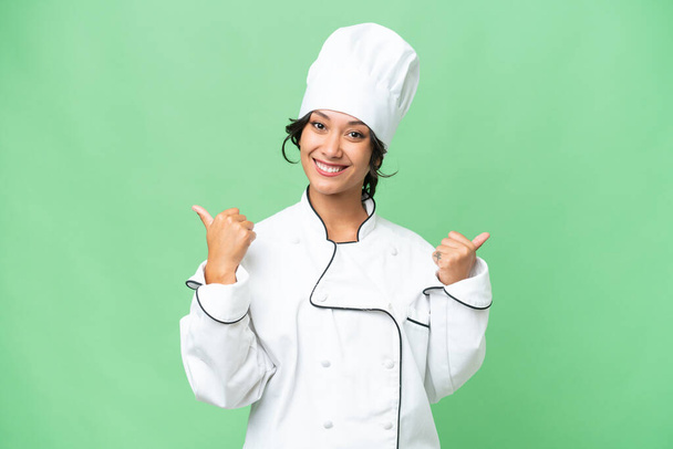 Joven chef argentina sobre fondo aislado con pulgares hacia arriba gesto y sonriente - Foto, Imagen