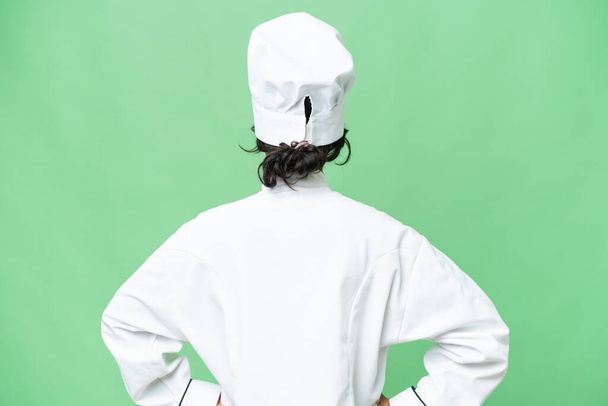 Young chef Argentinian woman over isolated background in back position - Foto, Imagem