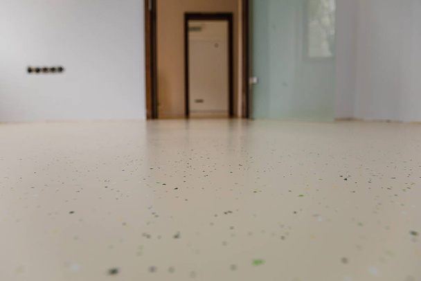Egy egészségügyi létesítmény új dekoratív epoxi padlóval. Színes zsetonok beágyazva a varrat nélküli felületen hozzon létre egy élénk és tartós megoldást.Szelektív fókusz - Fotó, kép