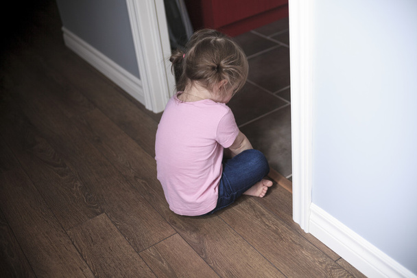 Portrait of sad little girl standing near wall in the day time - Φωτογραφία, εικόνα