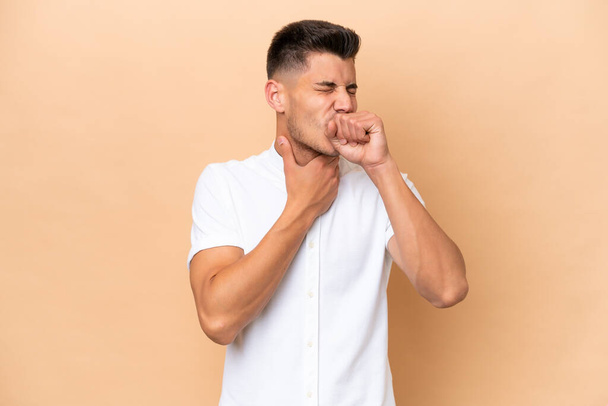 Young caucasian man isolated on beige background coughing a lot - Foto, imagen