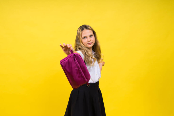 Little teenager girl with pencil case on a yellow background - Foto, Imagem