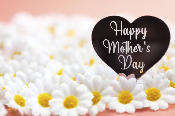 Cartão de dia de mães felizes com fundo rosa pastel brilhante e flores de margarida branca, Tema do Dia das Mães, conceito de coração rosa com espaço de cópia para texto - Foto, Imagem