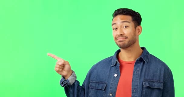 Face, man and hand pointing to green screen studio for commercial promotion, advertising and mockup. Portrait, happy and asian male showing space, product placement and isolated copy space list. - Footage, Video
