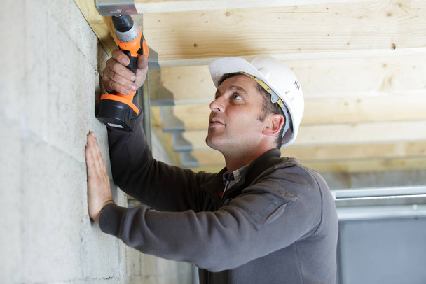 handyman mature home improvement drilling wood - Foto, Imagen