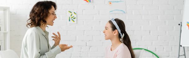 Side view of speech therapist talking to preteen girl in consulting room, banner  - Фото, зображення