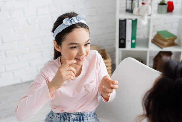 Carefree pupil taking to blurred speech therapist in consulting room  - Photo, Image