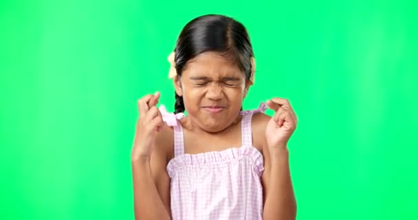 Kind, wens en vingers gekruist op groen scherm voor geluk of geloof. Meisje kind of ogen gesloten emoji voor hoop, bidden en wonder of hulp op studio achtergrond ruimte met mockup ruimte terwijl hoopvol. - Video