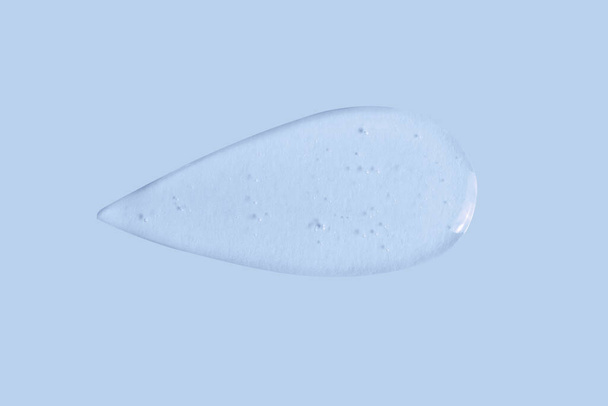 textura de una gran mancha de gel transparente sobre un fondo azul - Foto, Imagen