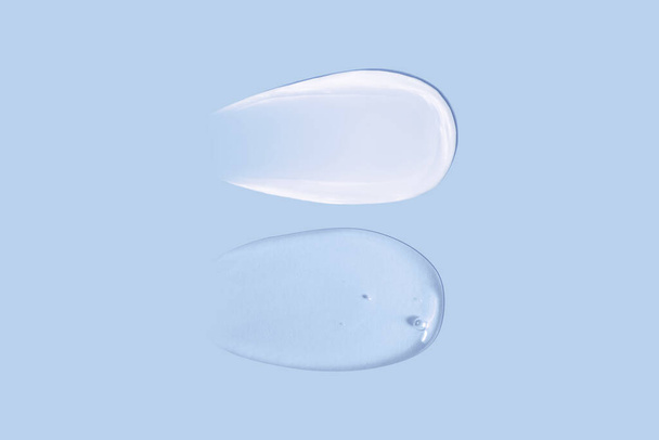 Texture de frottis crème et texture de frottis gel transparent sur fond bleu - Photo, image
