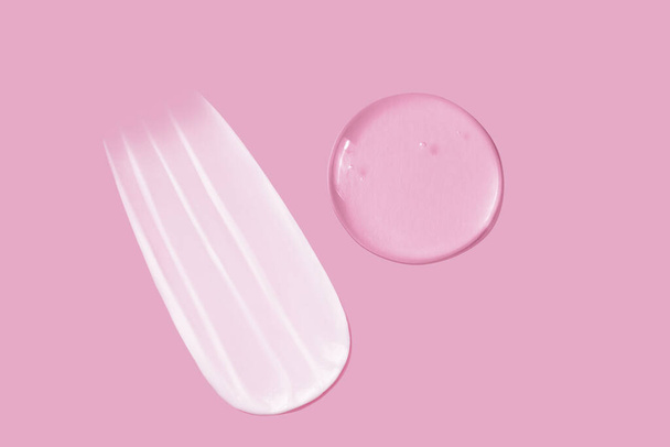 Textura de frotis de crema y textura de frotis de gel transparente sobre fondo rosa - Foto, Imagen