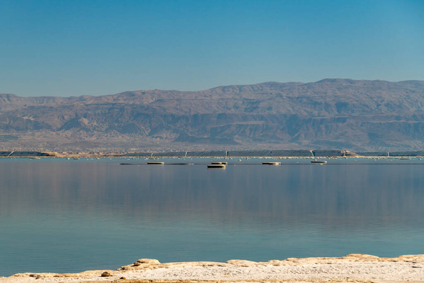 View of the brilliant colors of the Dead  Sea and reflection of the Jordanian mountains at sunrise  on a Winter's day in Israel. - Fotografie, Obrázek
