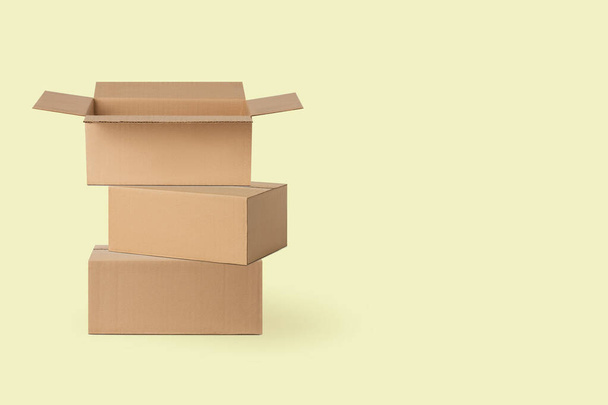 several cardboard boxes for delivery, parcels. On a yellow background. - Fotó, kép