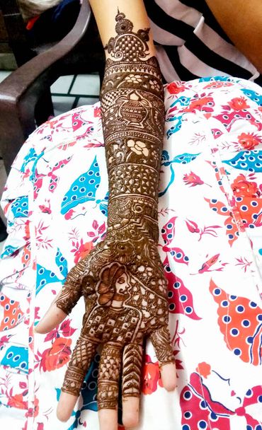 Una hermosa obra de arte dibujada en la mano de una novia india con heena de hierbas en estado húmedo. - Foto, imagen