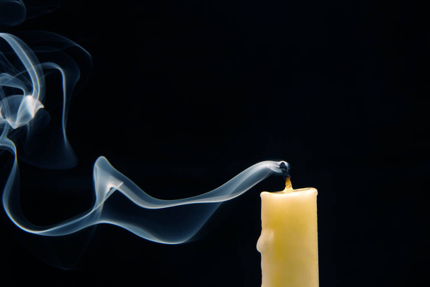 Fumée provenant d'une bougie éteinte sur un fond sombre. Le concept de spiritualité et la fin de vie. - Photo, image