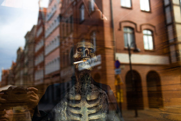 Відкритий декор для Helloween. Мертвий власник у вікні будинку. Скелетон. Ландшафт Хелловін. Фотографія високої якості - Фото, зображення