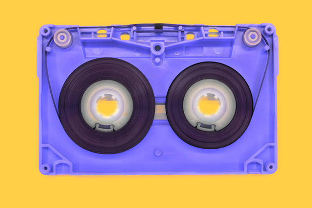 nastro blu vecchio audiocassetta aperto su sfondo giallo - Foto, immagini