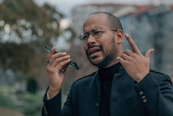 Latin férfi beszél a mobiltelefon kezek ingyenes vagy hangüzenet küldése - Fotó, kép