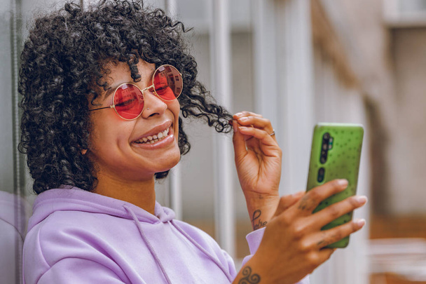 afro dziewczyna z telefonem komórkowym i okulary przeciwsłoneczne - Zdjęcie, obraz
