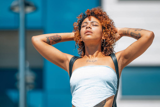 chica negra afroamericana latina con tatuajes disfrutando al aire libre en la calle - Foto, imagen