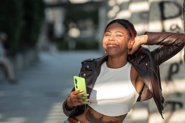 afro chica urbana con teléfono móvil en la calle - Foto, Imagen