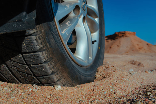 Car wheel on sand close-up view - Foto, Imagem