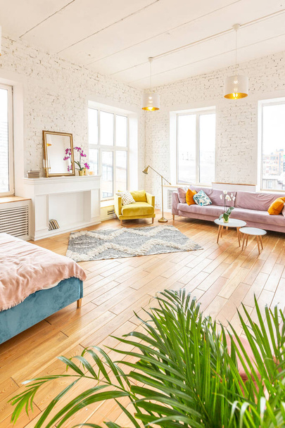 very light and spacious two-rooms apartment in Scandinavian design style with fashion furniture and large windows. warm colors during day time - Photo, Image