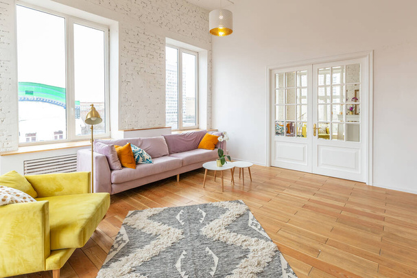 very light and spacious two-rooms apartment in Scandinavian design style with fashion furniture and large windows. warm colors during day time - Foto, imagen