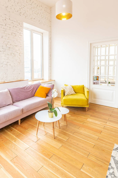 Scandinavian style apartment interior. bright yellow warm colors. wooden flooring. sunlight in large windows. - Foto, Bild