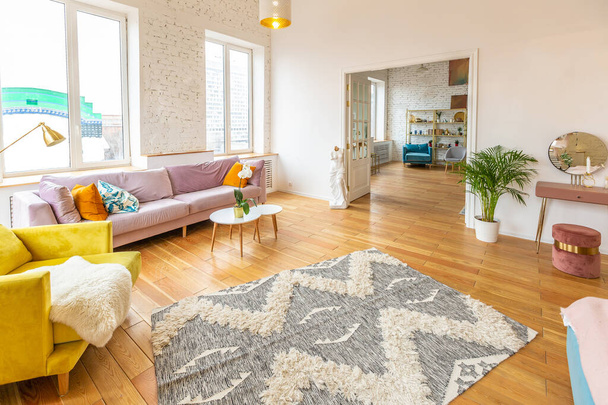 very light and sparcious two-rooms apartment in scandinavian design style with fashion furniture and large windows. warm colors during day time - Zdjęcie, obraz