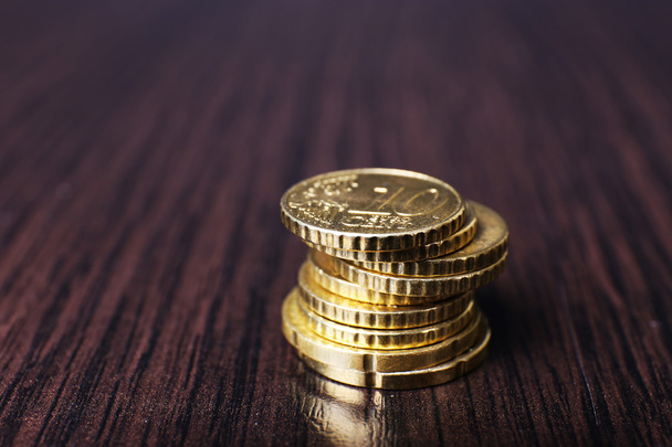 Stack of golden coins on wooden table background - Photo, image