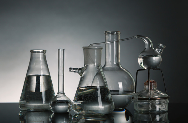 Fixed laboratory glassware on dark  background - Фото, зображення