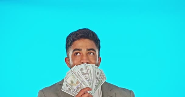 Üzletember, pénz rajongó és a stúdió győztese elszigetelve egy kék háttérképpel. Készpénz, nyertes és gazdag indiai személy gondolkodás vagy ötlet dollár után lottó, bónusz díj vagy pénzügyi szabadság - Felvétel, videó