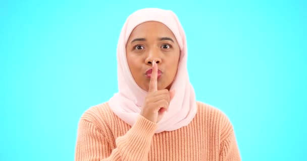Мусульманская женщина, тайна и палец на губах для макета, молчания или продвижения по службе. Исламская женщина с хиджабом и портретом смайлика для объявления, сплетен и приватности или сюрприза на голубом фоне студии. - Кадры, видео