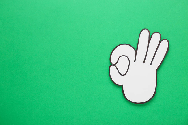 Paper cutout of okay hand gesture on green background, top view. Space for text - Foto, Imagen