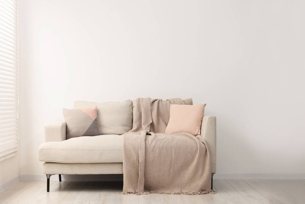 Acogedor sofá con almohadas y manta en el salón. Diseño de interiores - Foto, imagen