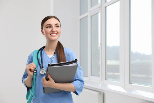 Smart medical student with folders in college hallway, space for text - Photo, image