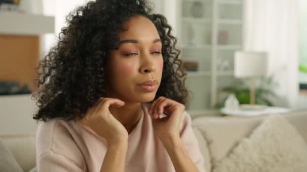 Szoros arc szomorú figyelmes fiatal afro-amerikai egyedülálló nő néz félre gondolkodás problémák. Színes nő ül a kanapén egyedül a modern otthon problémás negatív gondolat lassított 4K - Felvétel, videó
