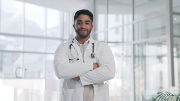 Doctor, man and arms crossed, face and smile with confidence and pride, healthcare and surgeon in hospital. Happy male physician, health and medical professional with expert in medicine in portrait. - Footage, Video